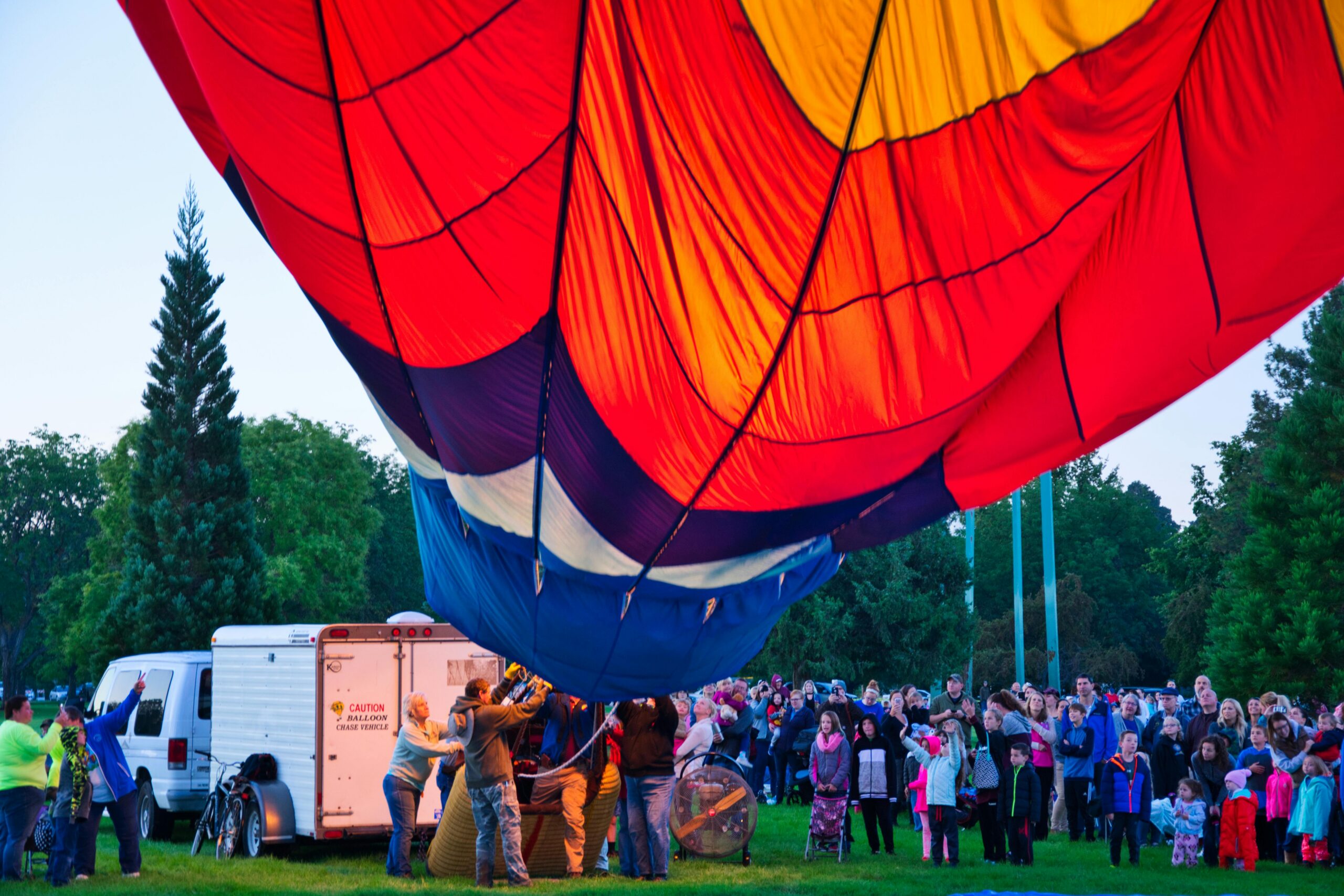 Vibrant hot air balloon launch gathering at a park in Boise, Idaho.